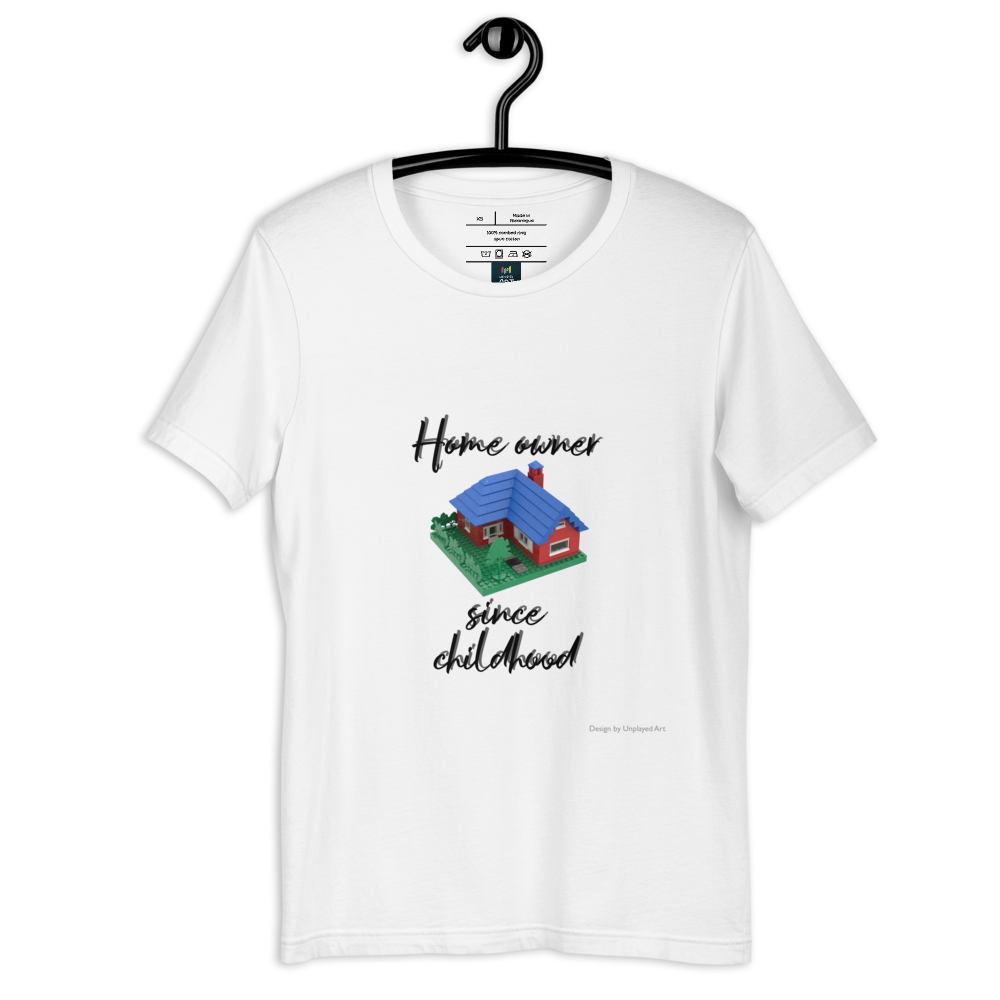 White t-shirt on a hanger, with a picture of a town house made out of LEGO bricks, and the wording "Home owner since childhood"