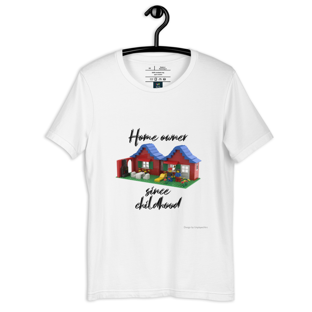 White t-shirt on a hanger, with a picture of a house and garden made out of LEGO bricks, and the wording "Home owner since childhood"