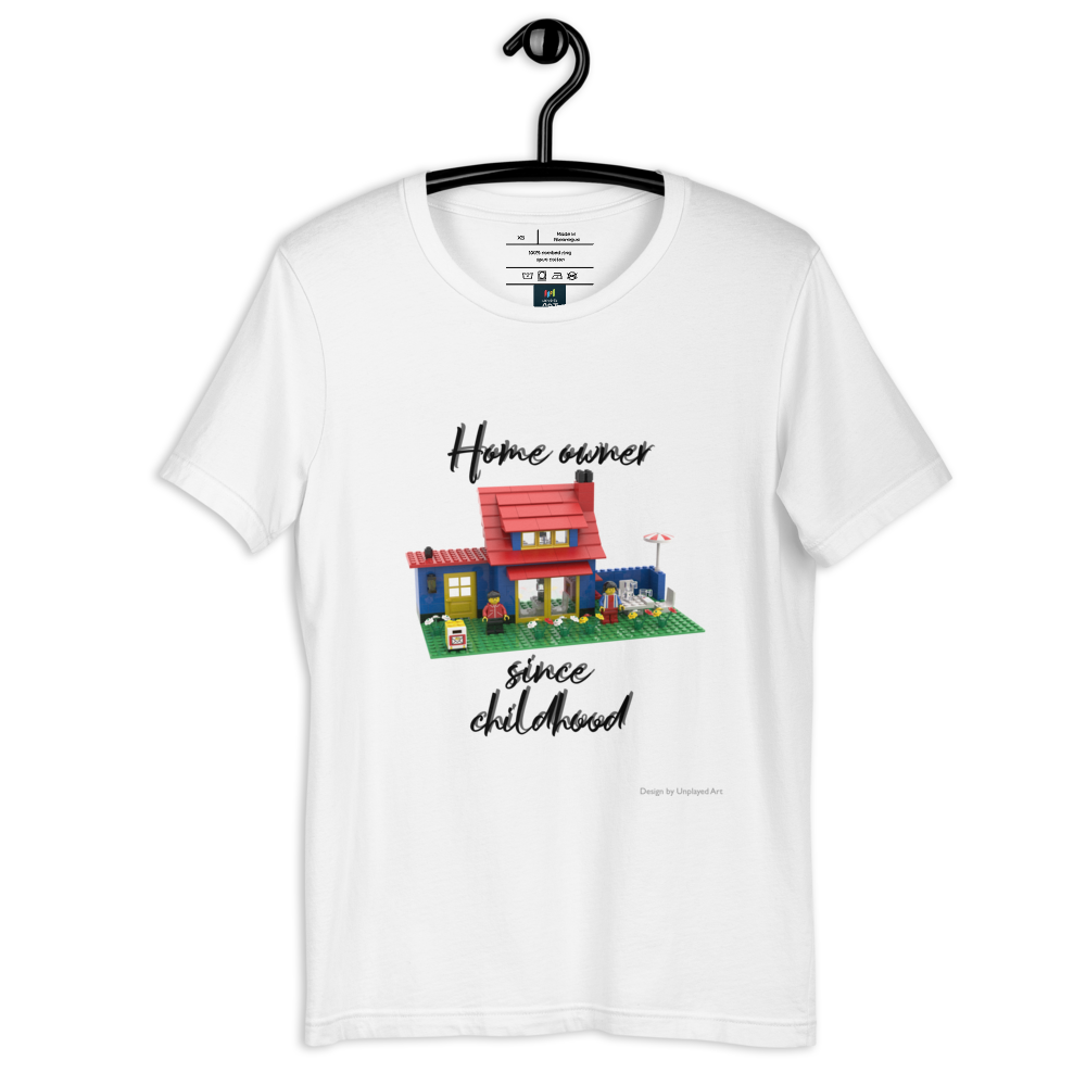 White t-shirt on a hanger, with a picture of a double-storey house made out of LEGO bricks, and the wording "Home owner since childhood"