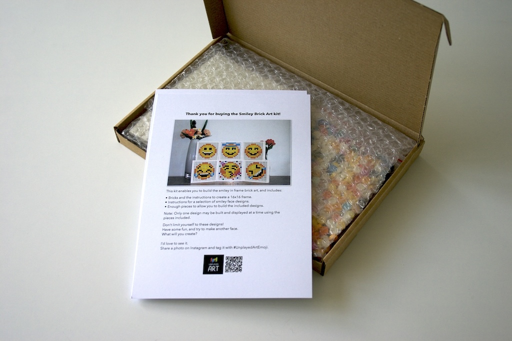 Smiley Brick Art Kit open box with instruction sheets laid on top.